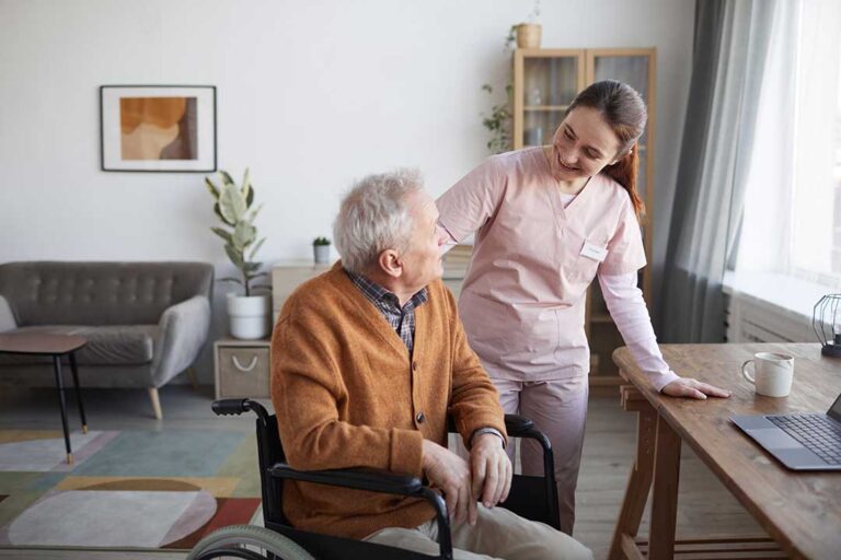 Older resident choosing clothes beside a caregiver in a bright, organized bedroom.